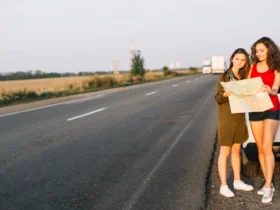 Women standing near white car with map