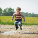 Children Boy Jumping Near Grass at Daytime