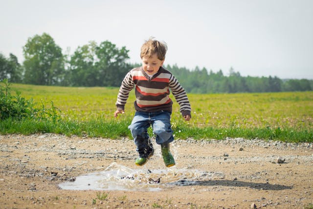 Children Boy Jumping Near Grass at Daytime