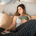 A Woman Resting on the Bed with Her Baby on Top