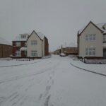 Houses and surrounding areas are covered in snow