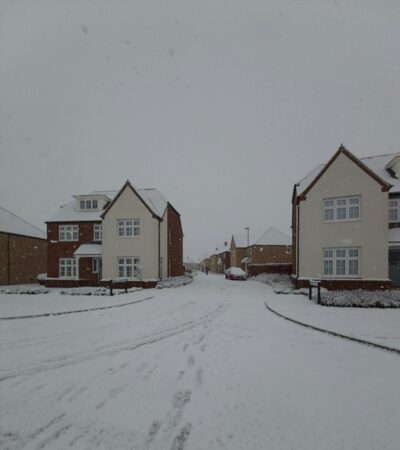 Houses and surrounding areas are covered in snow