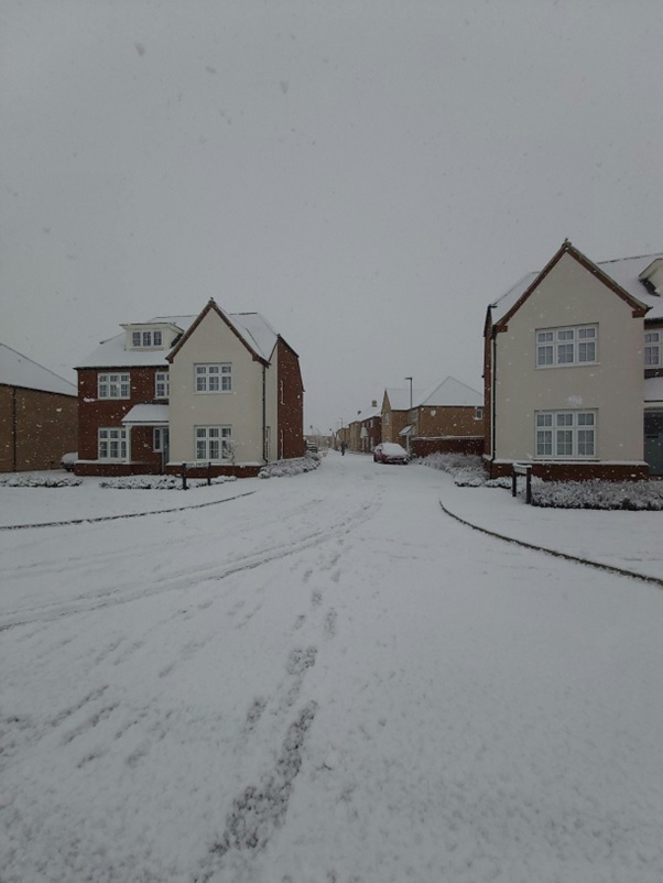 Houses and surrounding areas are covered in snow