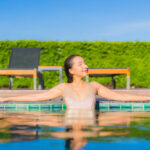 young asian woman relaxing around outdoor swimming pool