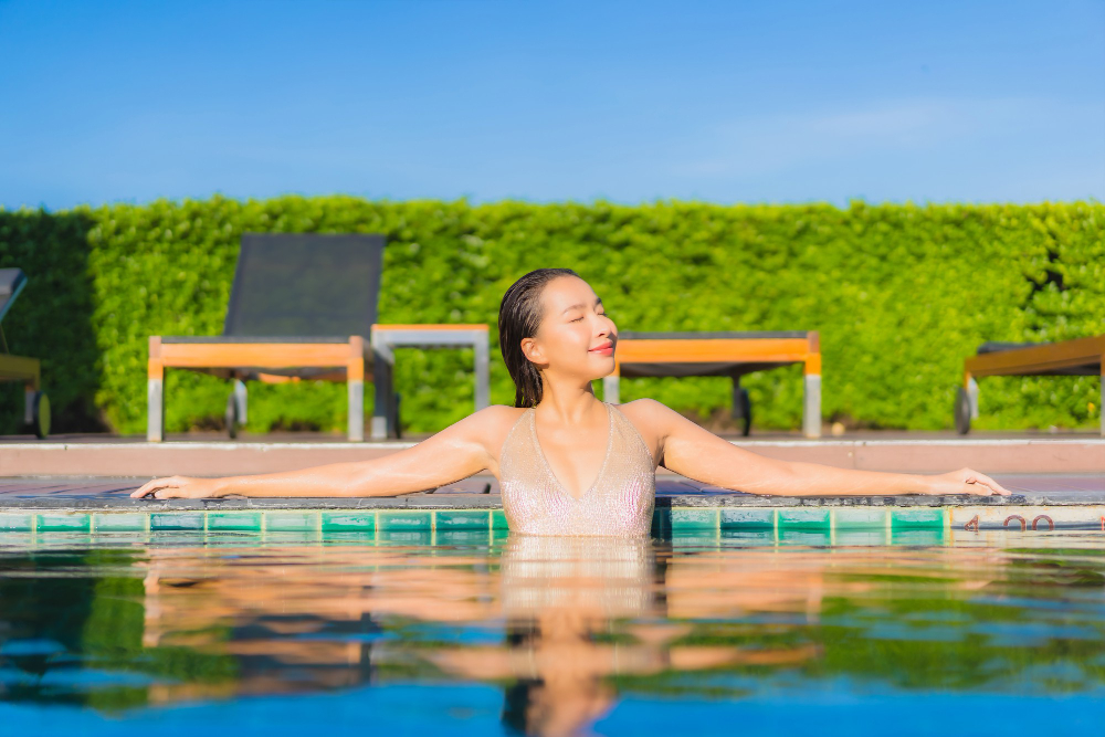 young asian woman relaxing around outdoor swimming pool