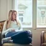 Woman Sitting on Chair Near Window