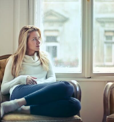 Woman Sitting on Chair Near Window