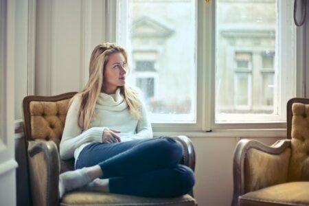 Woman Sitting on Chair Near Window