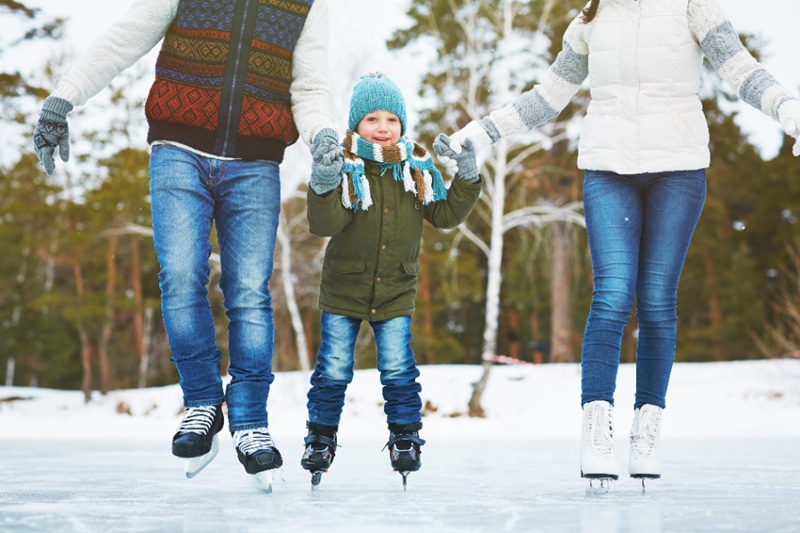 family skating on frozen lake