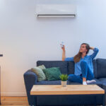 woman sitting on couch under air conditioner