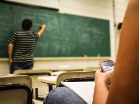 Man in Black and White Polo Shirt Beside Writing Board